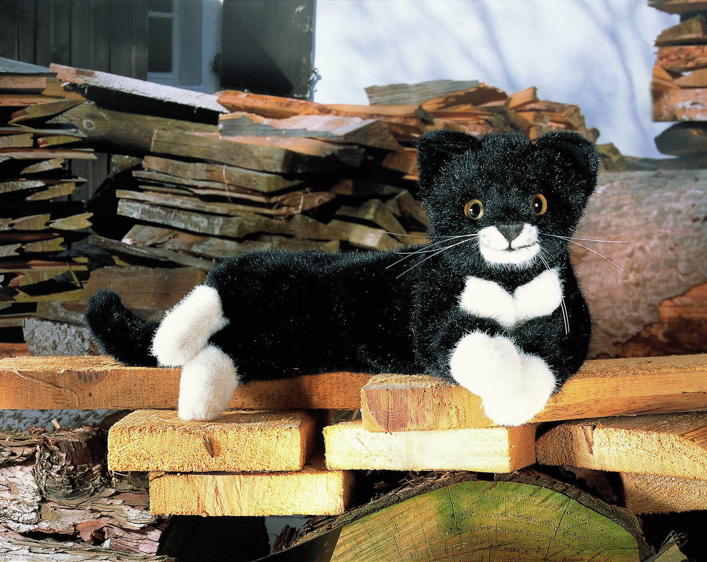 Kuscheltier. Liegende, schwarz weiße, Katze. Handgefertigt von Koesen Spielzeugmanufaktur. Kaufen bei nordic soul Shop in Rostock.