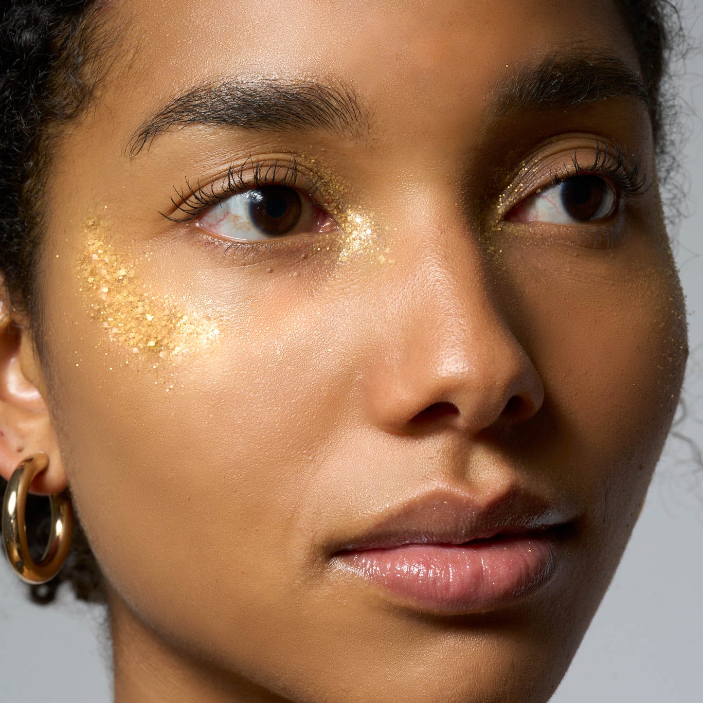 Model mit goldenem Glitzer im Gesicht