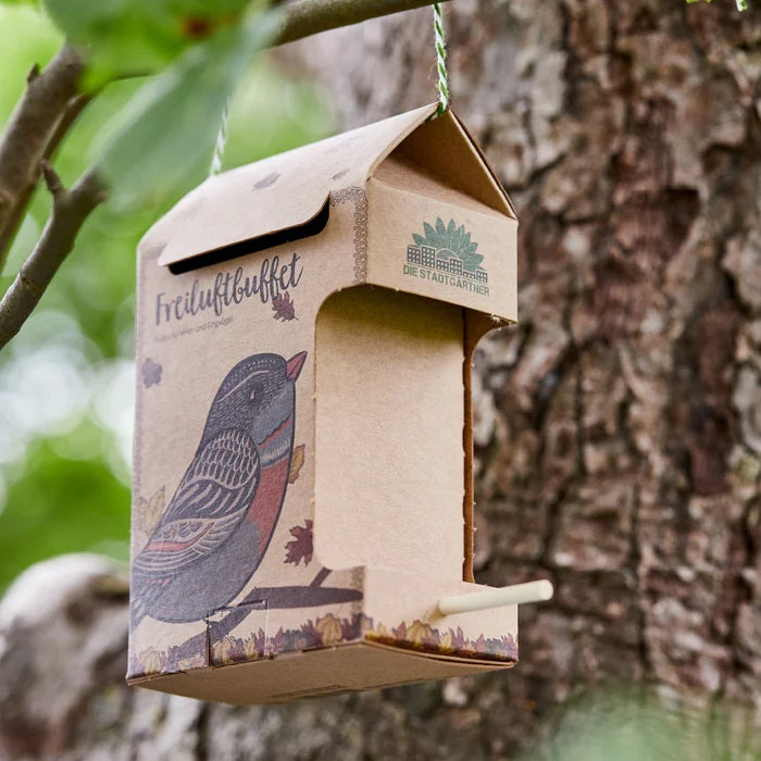 futterhaus aus karton haengend am baum fuer voegel mit futter