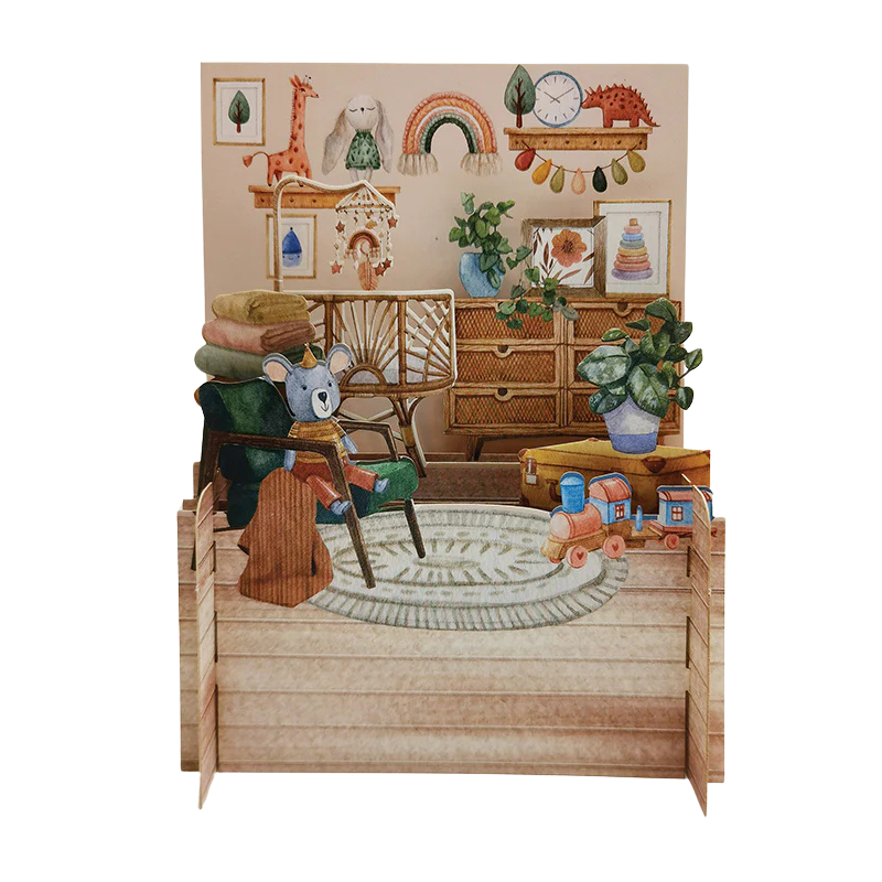Eine Pop-up Grußkarte zum hinstellen mit einem Babyzimmer mit Spielzeug und einem Bettchen.