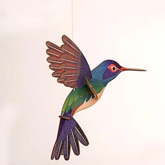 Der hängende Kolibri in bunten Farben und flatternden Flügeln.