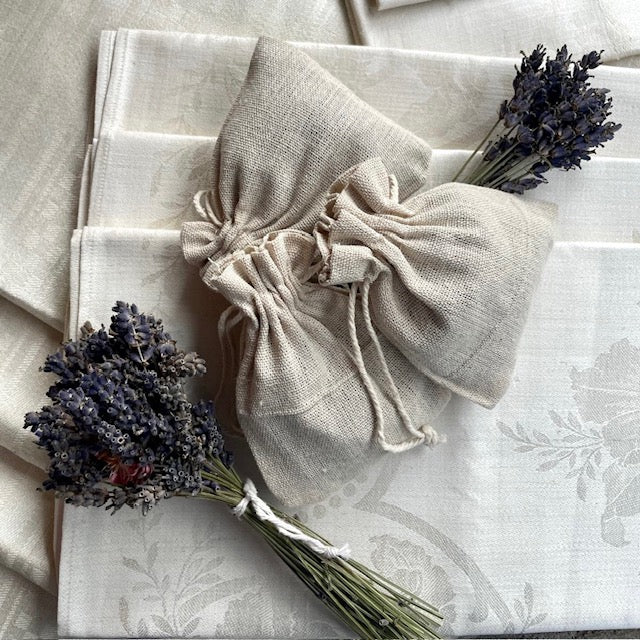 Alte Leinentücher mit Lavendelbeutel und Lavendelsträussen.