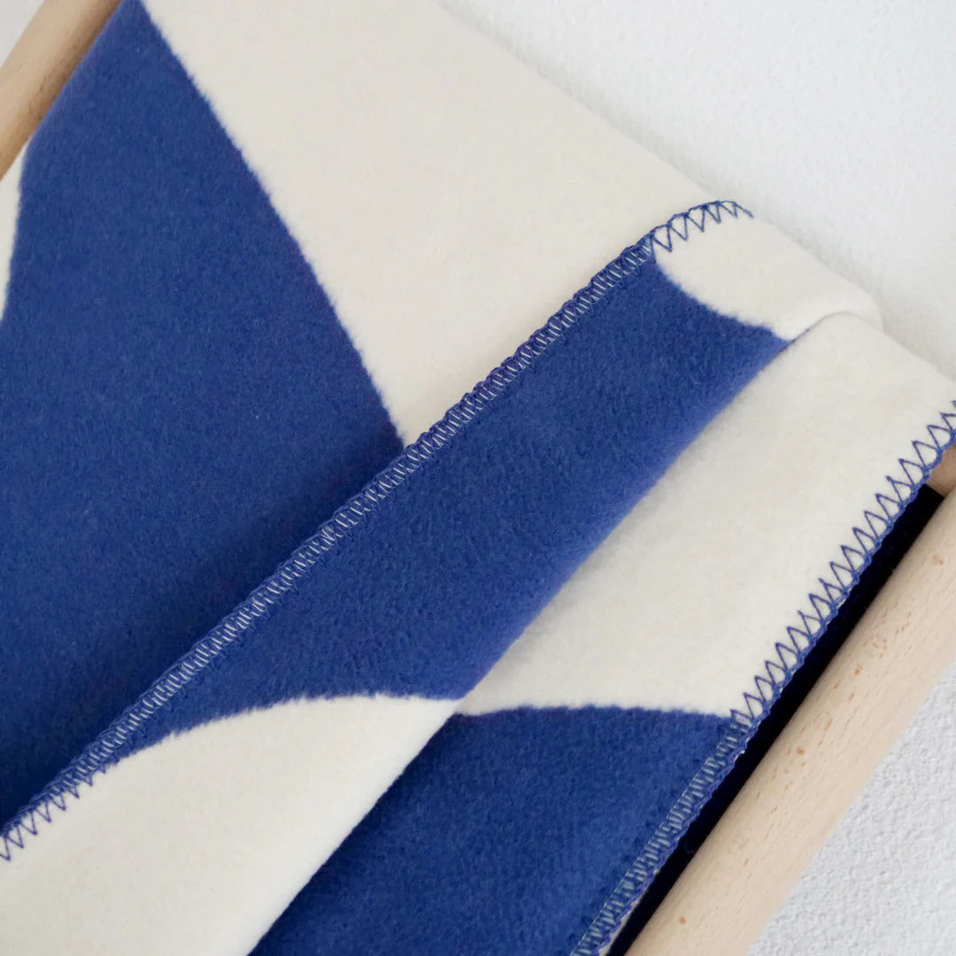 Baumwolldecke mit grafischem blau und beigen Muster.