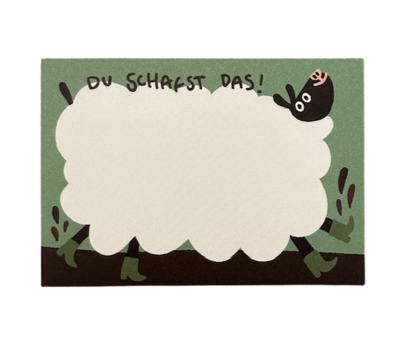 Notizblock mit einem dicken, weißen Schaf mit Gummistiefeln. Text dazu, du schafst das.