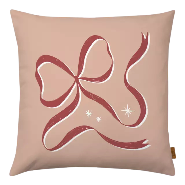 Ein Kissenbezug in altrosa mit einer roten Schleife.