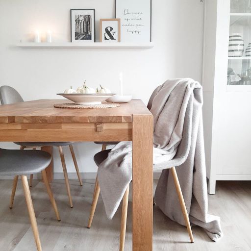 Baumwolldecke zum Wenden in beige und grau, hängend über einem Stuhl.