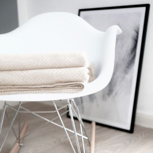 Baumwolldecke zum
Wenden n beige und sand, liegend auf einem Stuhl.