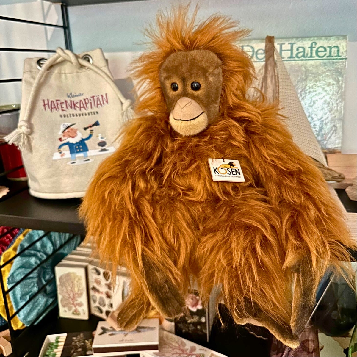 Ein flauschiger, braun-orangener Orang Utan als Kuscheltier.