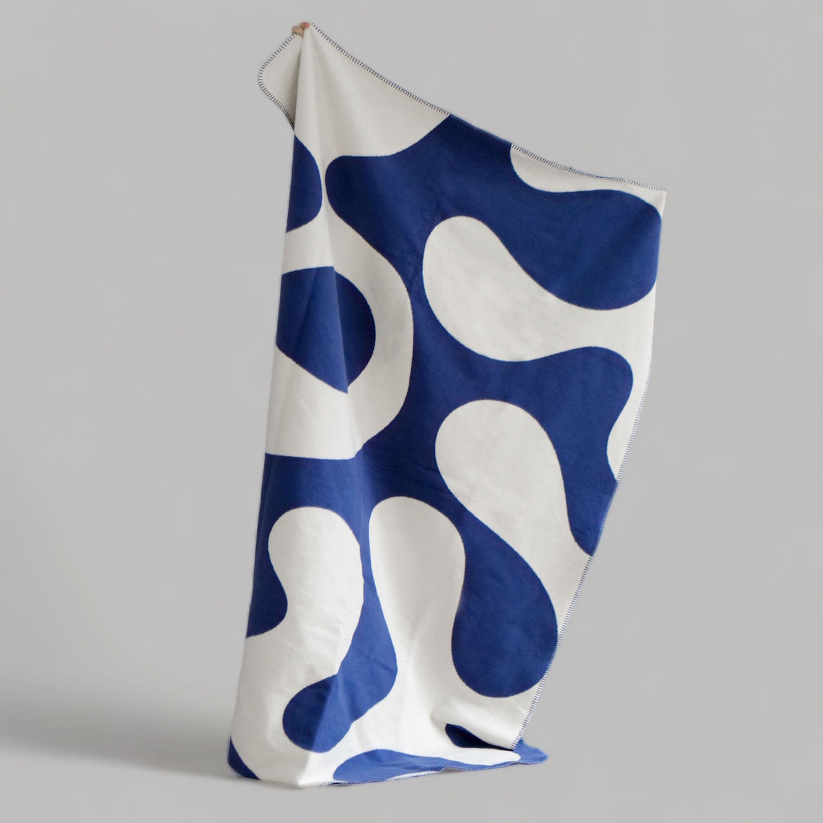 Eine blau-beige Kuscheldecke.