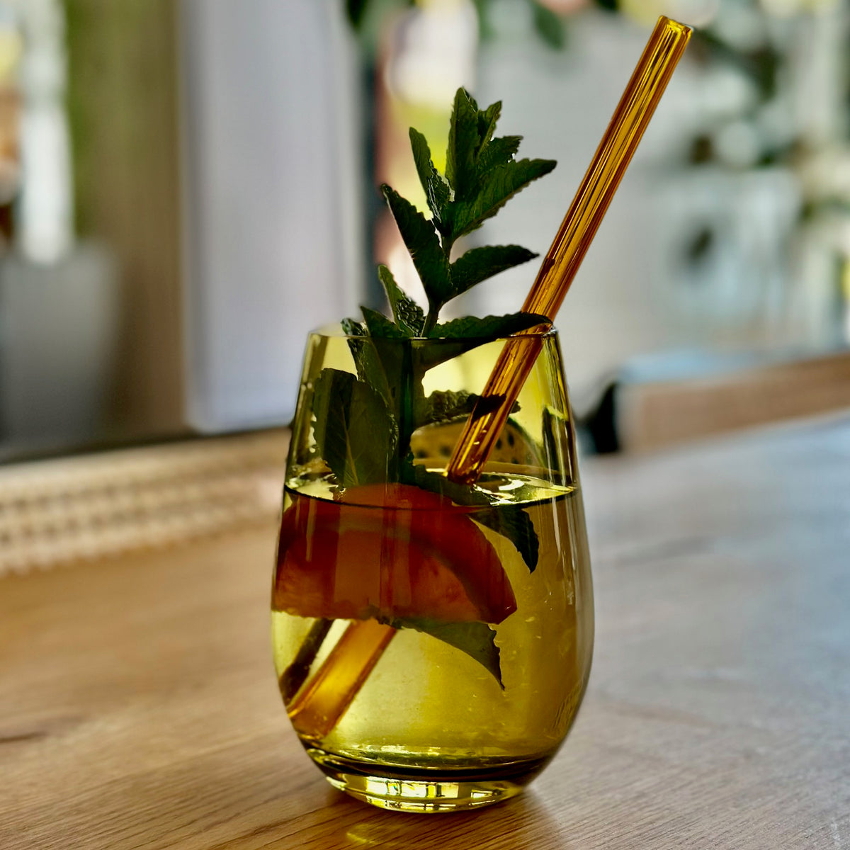 gelbes glas mit glastrinkhalm und pfefferminze