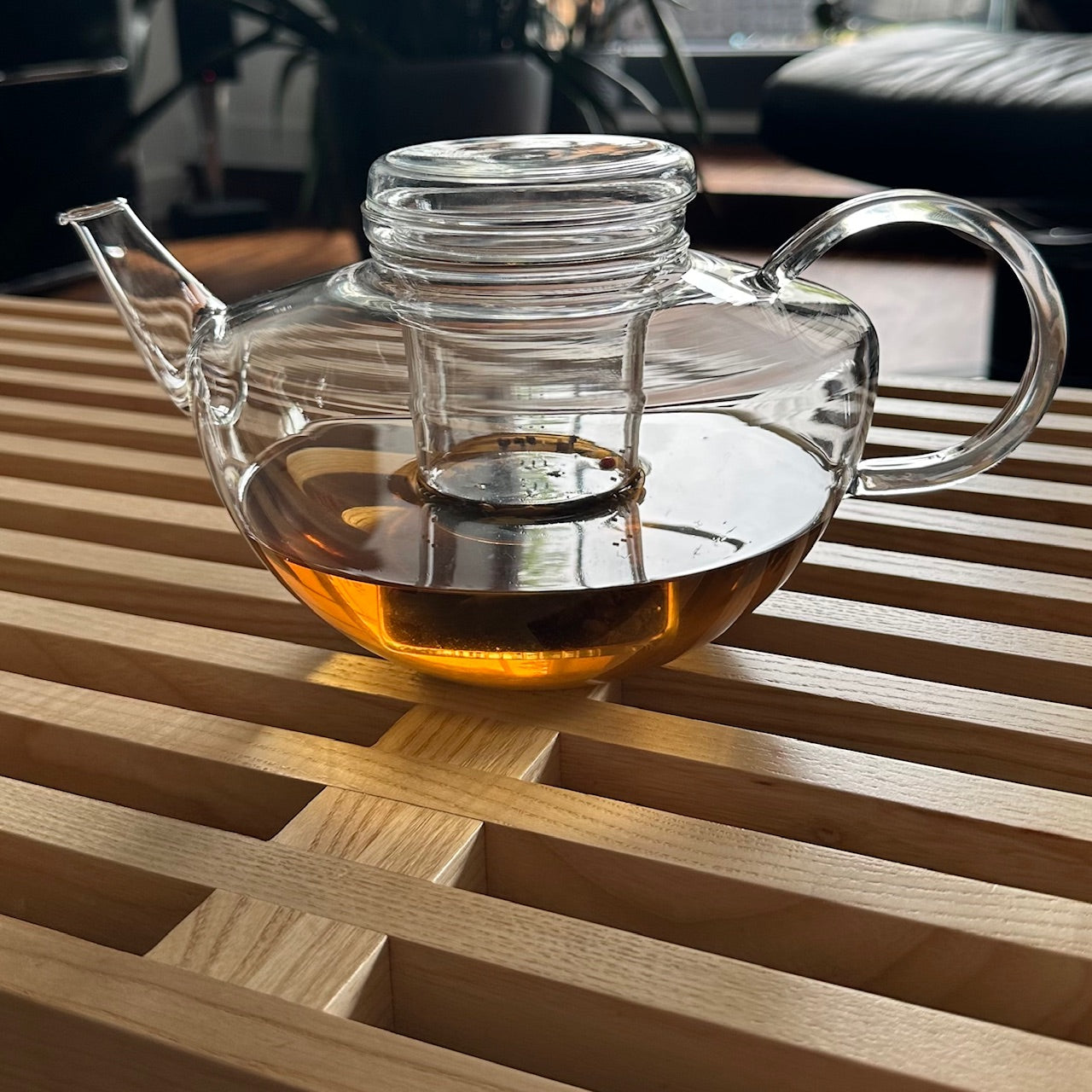 glas teekanne mit teesieb aus glas und glasdeckel auf dem Tisch