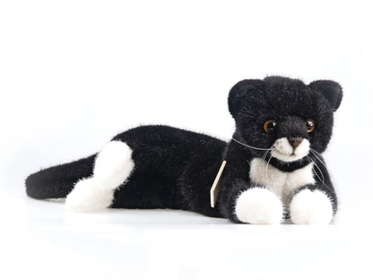 Kuscheltier. Liegende, schwarz weiße, Katze. Handgefertigt von Koesen Spielzeugmanufaktur. Kaufen bei nordic soul Shop in Rostock.