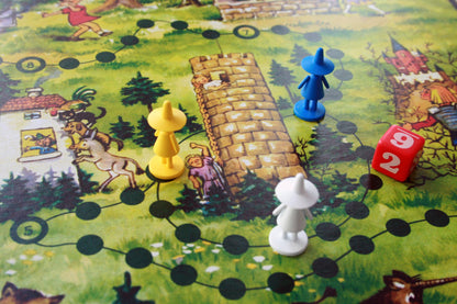 brettspiel aus karton mit bunten spielfiguren und wuerfel im maerchenland