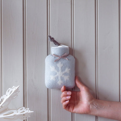 kleine hellgraue waermflasche mit weißem schneeflocke motiv