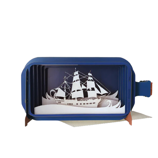 Eine pop-up Grußkarte in Form einer Flaschenpost mit einem weißen Segelschiff und Wellen. 