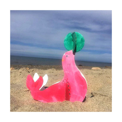 bunt bemalte robbe aus karton am strand dekoriert