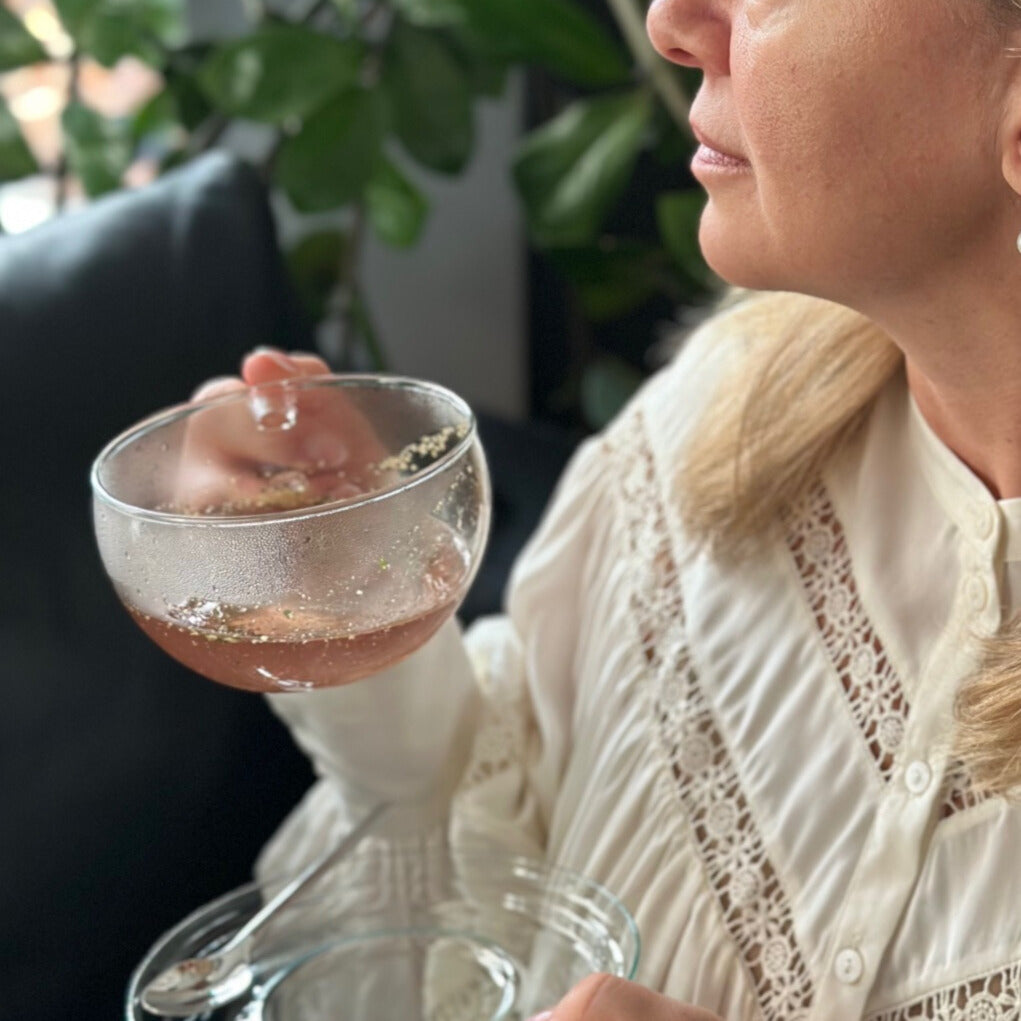Eine Frau hält eine Teetasse aus Borosilikatglas mit Tee. 