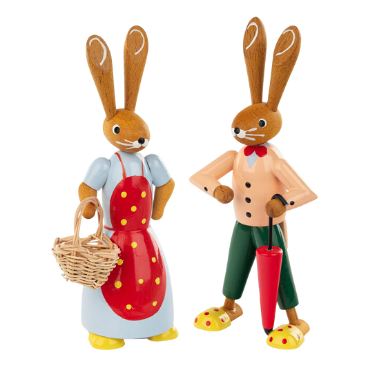 Hasenpaar aus Holz aus dem Erzgebirge. Häsin mit roter Schürze mit gelben Punkten und Korb. Hasenjunge mit grüner Hose und rotem Schirm.