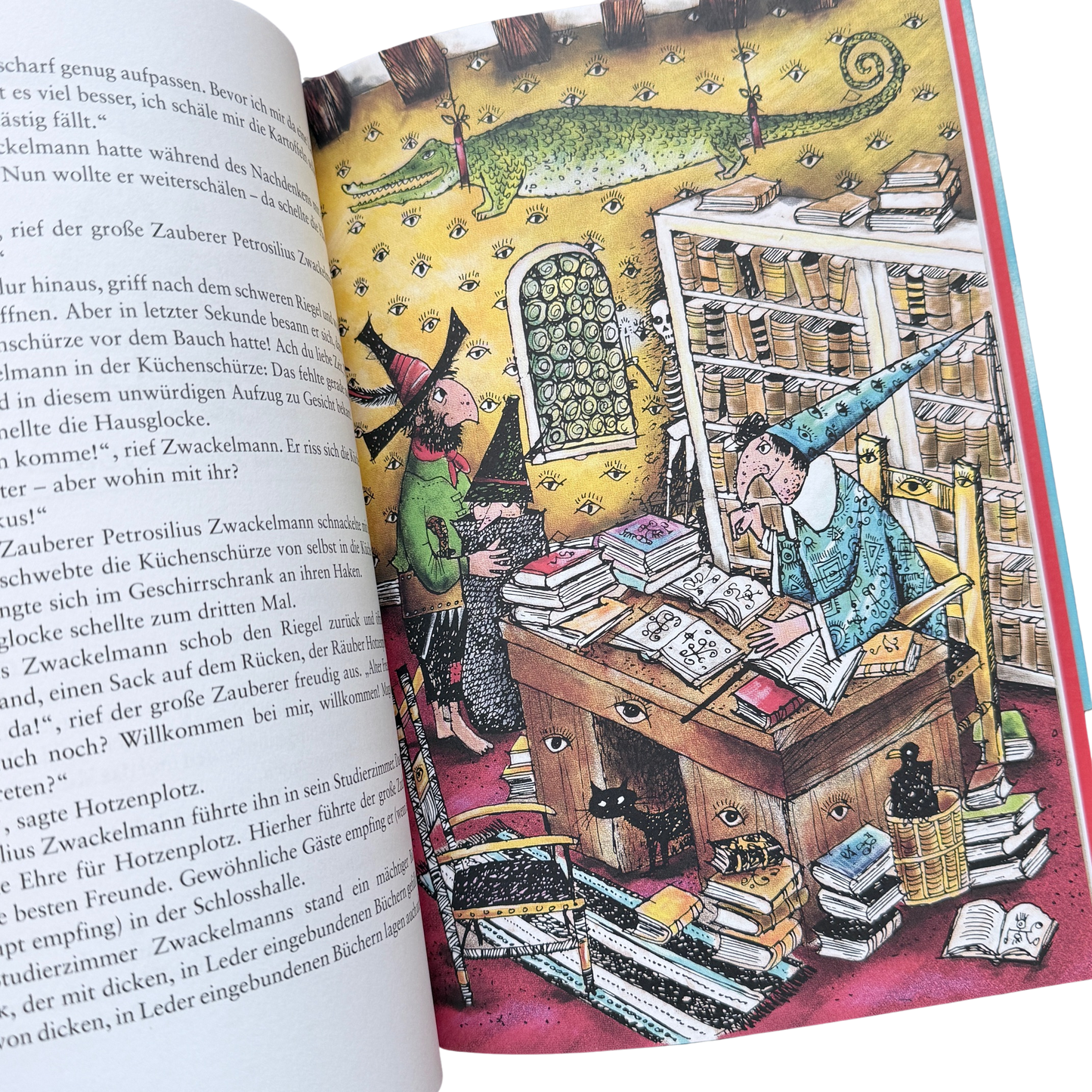 Räuber hotzenplotz ist im Schloss von Zauberer Zwackelmann und es stehen viele Bücher im Regal und ein Krokodil hängt von der Decke runter. 