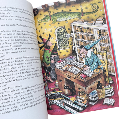 Räuber hotzenplotz ist im Schloss von Zauberer Zwackelmann und es stehen viele Bücher im Regal und ein Krokodil hängt von der Decke runter. 