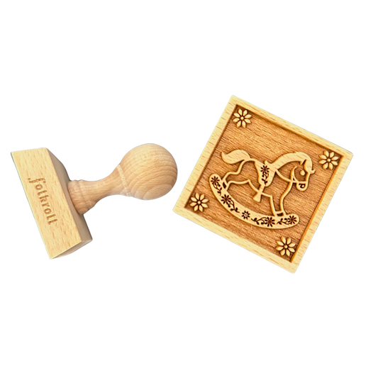 Ein Keksstempel aus Holz mit Schaukelpferdmotiv.