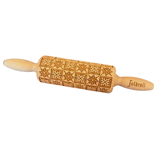 Eine kleine Teigrolle aus Holz mit Blumenquadraten als Motiv.