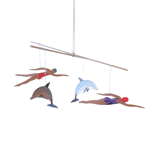 Ein Mobile Bastelset aus Holz mit zwei Schwimmerinnen und zwei Delfinen.