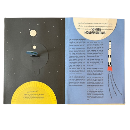 Kinderbuchseite mit einer Rakete, dem Weltall und der Erde mit Mond und Sonne. 