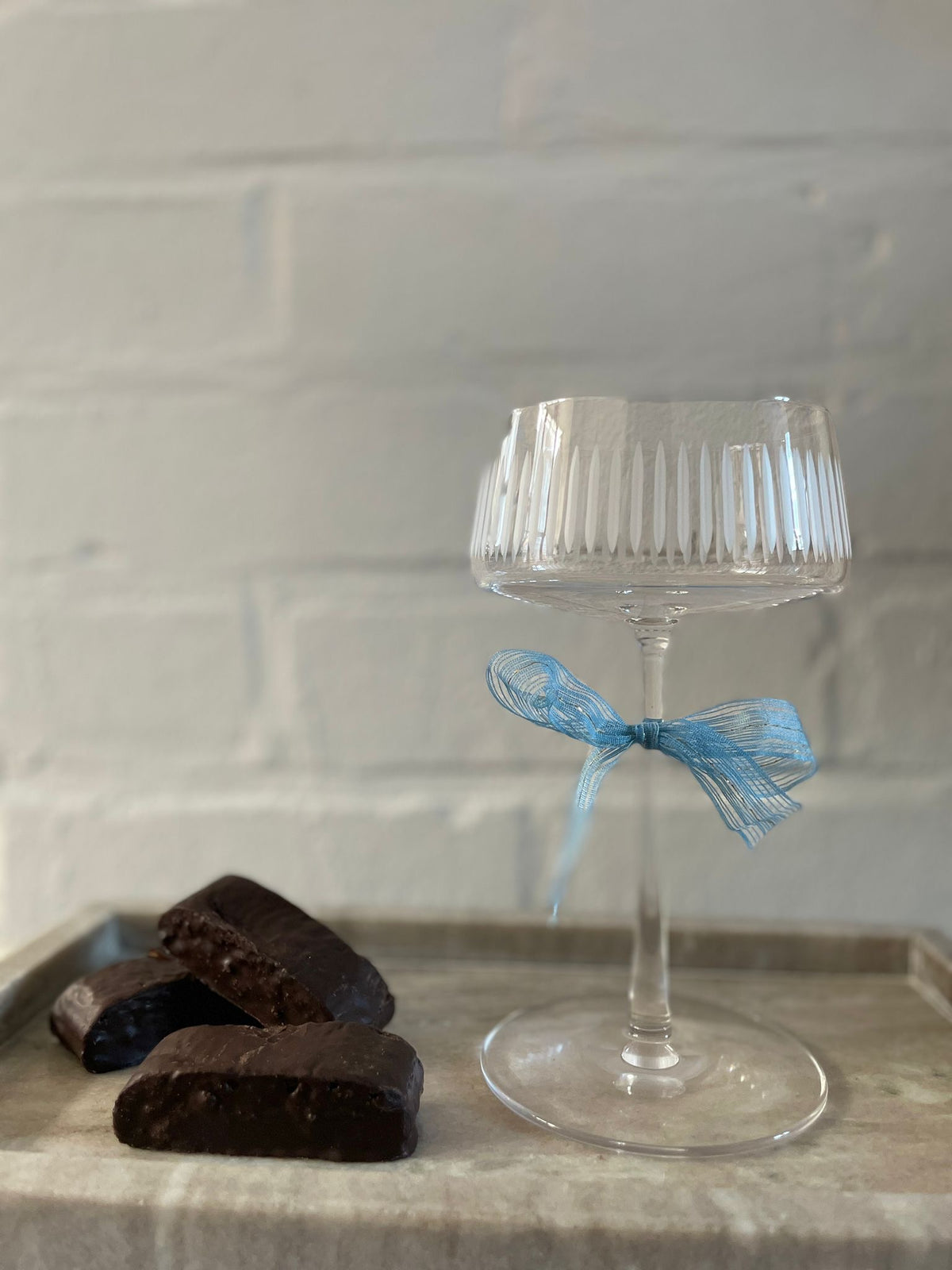 Champagner Glas auf einem Tablett mit Pralinen. 