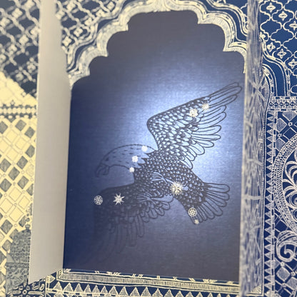 Eine beleuchtete Buchseite und ein Adler als Sternenzeichen wird sichtbar. 