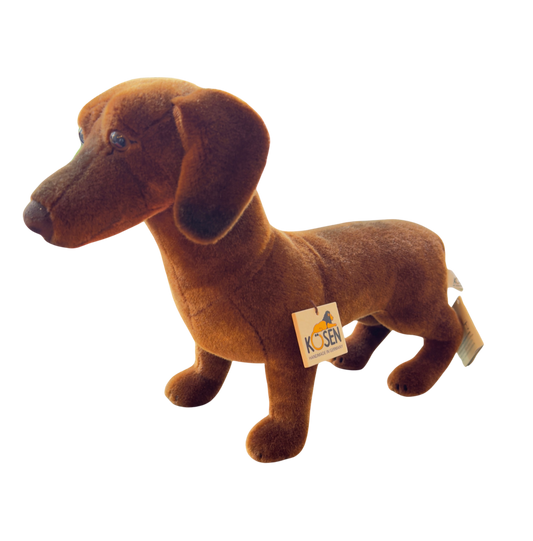 Kuscheltier Dackel Waldi aus Kösen auf einer Wiese mit Laub.