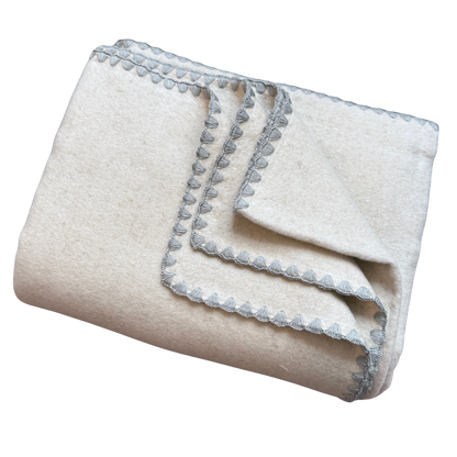Kuscheldecke aus Baumwolle und Leinen in Beige mit einem grauen Zierrand.