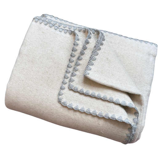 Kuscheldecke aus Baumwolle und Leinen in Beige mit einem grauen Zierrand.