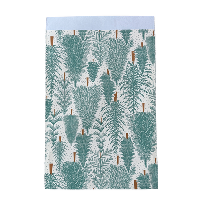 Geschenktüte mit einem Tannenwald Motiv.