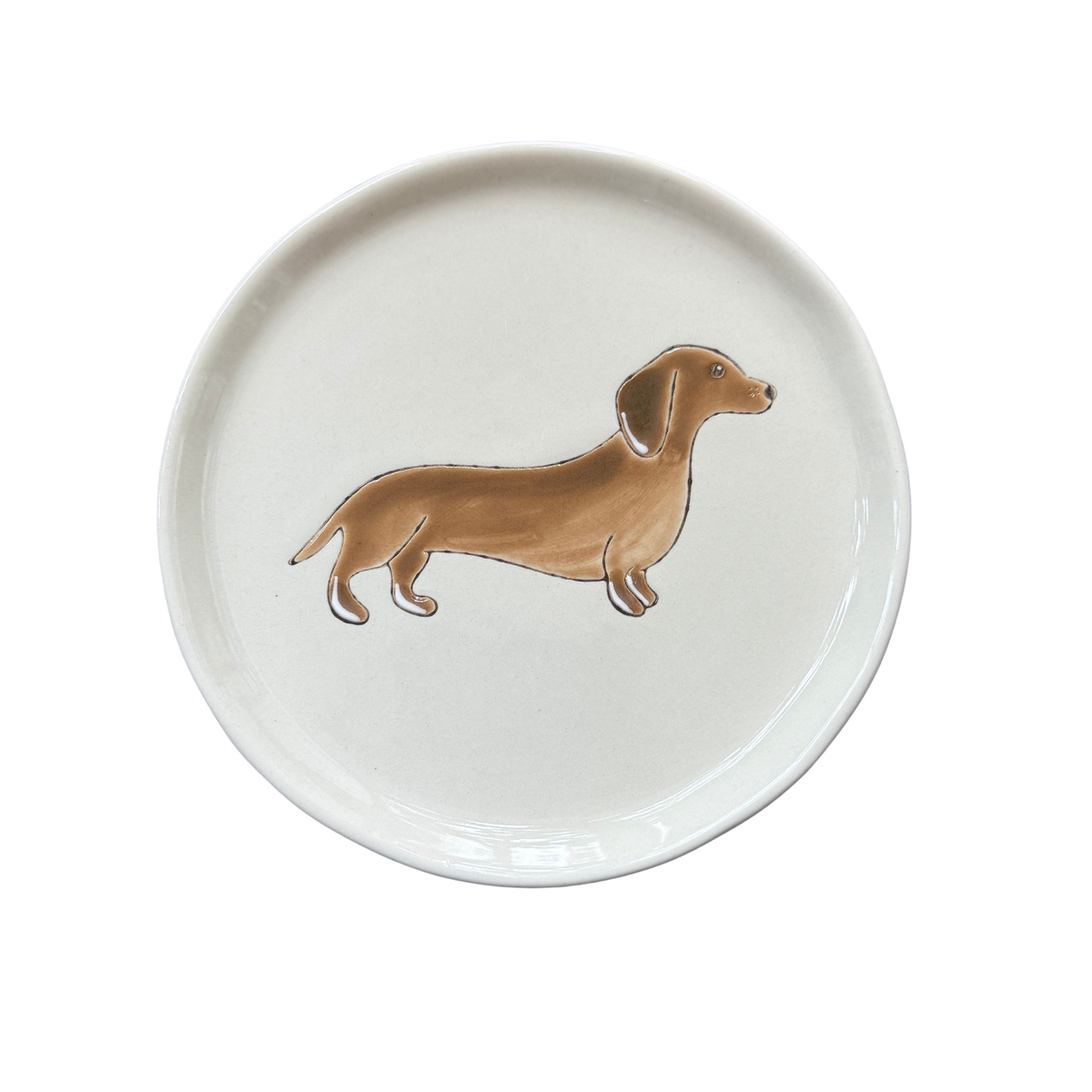 Kleiner Teller in Beige mit einme braunen Dackel als Dekor.