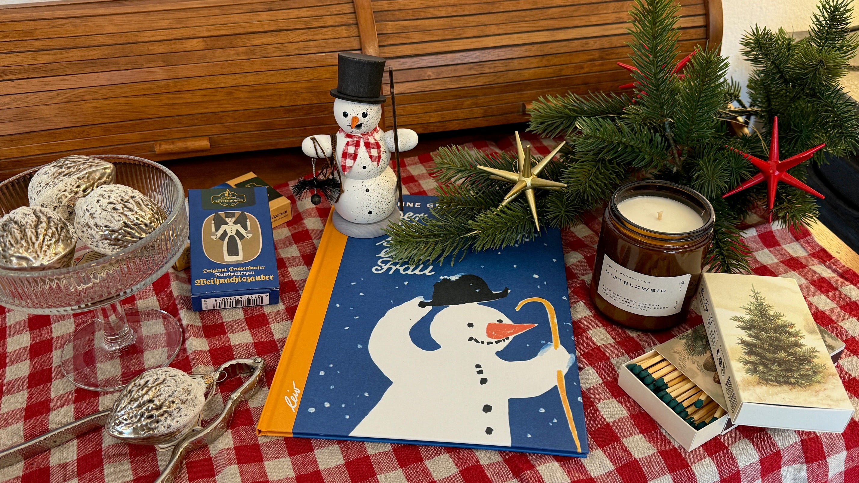 Weihnachtliche Collage mit Räuchermann, Kinderbuch, Duftkerze und Baumanhänger.