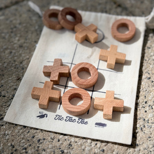 tic tac toe Spiel aus Holz auf einem Baumwollsäckchen als Spielfeld. 