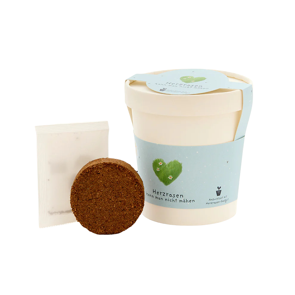 Saatgut, herzrasen kann man nicht mähen, ein Becher aus Pappe mit Gras-Saatgut welches aus dem Becher wächst. Inhalt.