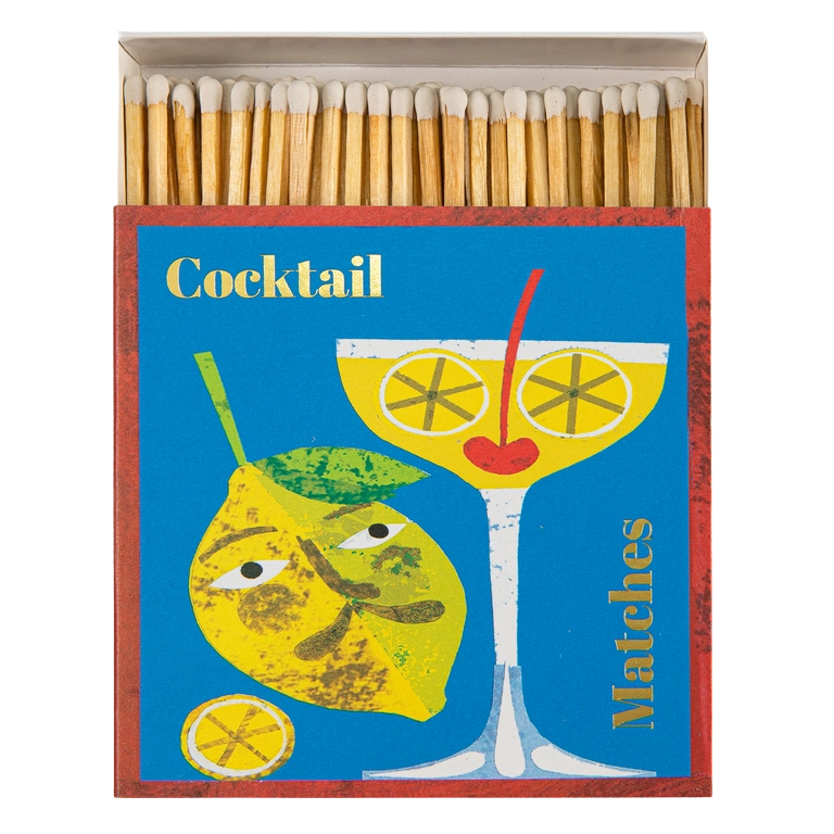 Streichhölzer in einer quadratischen Schachtel mit einem Cocktailglas mit einer Kirsche als Mund und Zitronen als Augen. Daneben eine männliche Zitrone. 