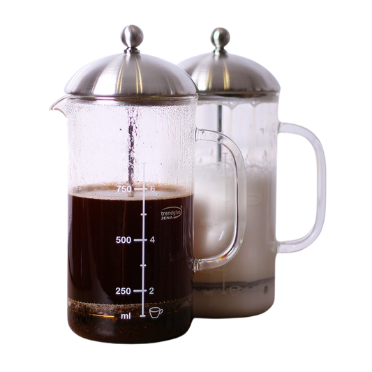 Zwei Frenchpress. Eine mit Kaffee und die andere mit aufgeschäumter Milch.