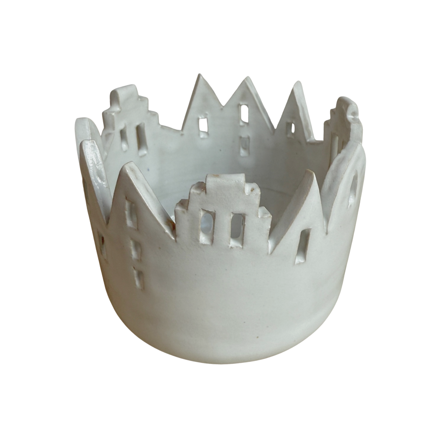 Ein weißes Windlicht aus Keramik mit Häusersilhouette.